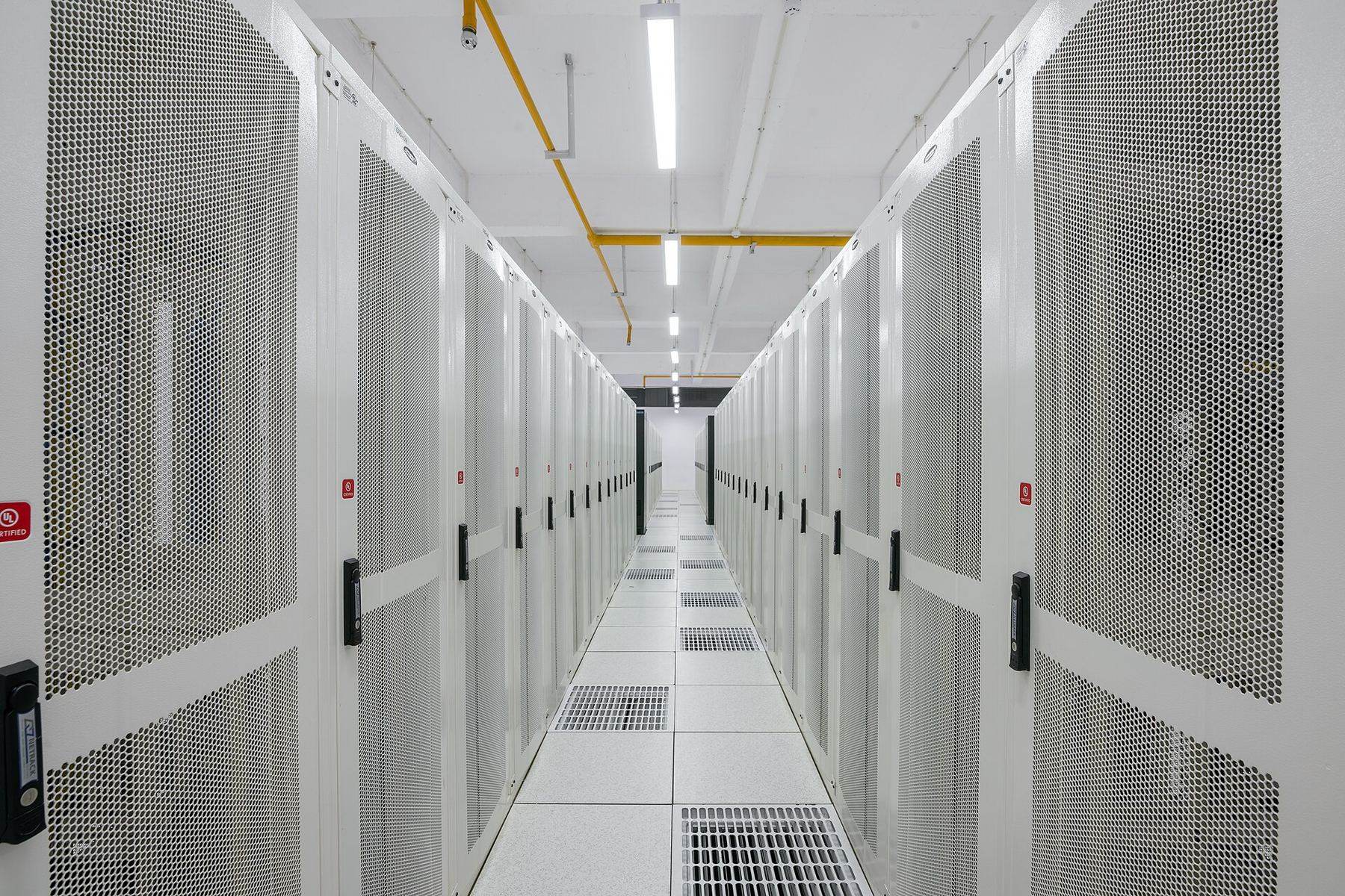 A bright, modern data centre corridor lined with server racks, representing the infrastructure behind Zerobitone's hosting and IT services